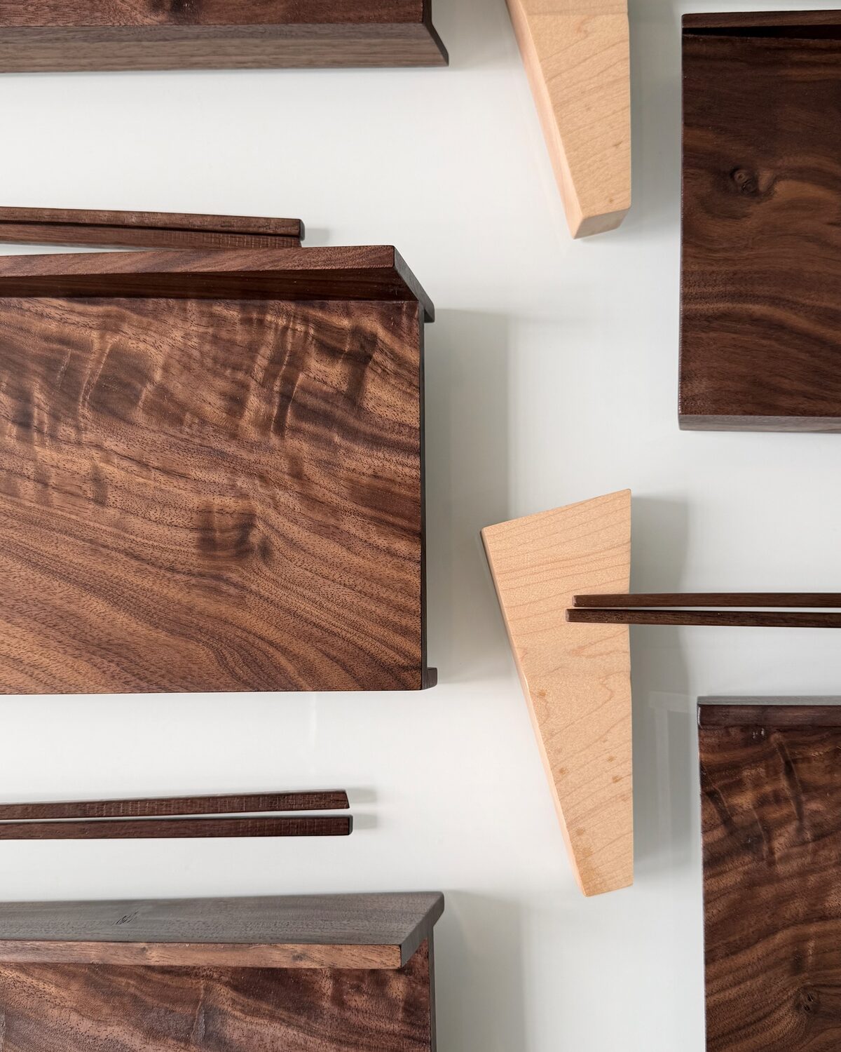 Figured walnut boards, angled and stacked in soft light