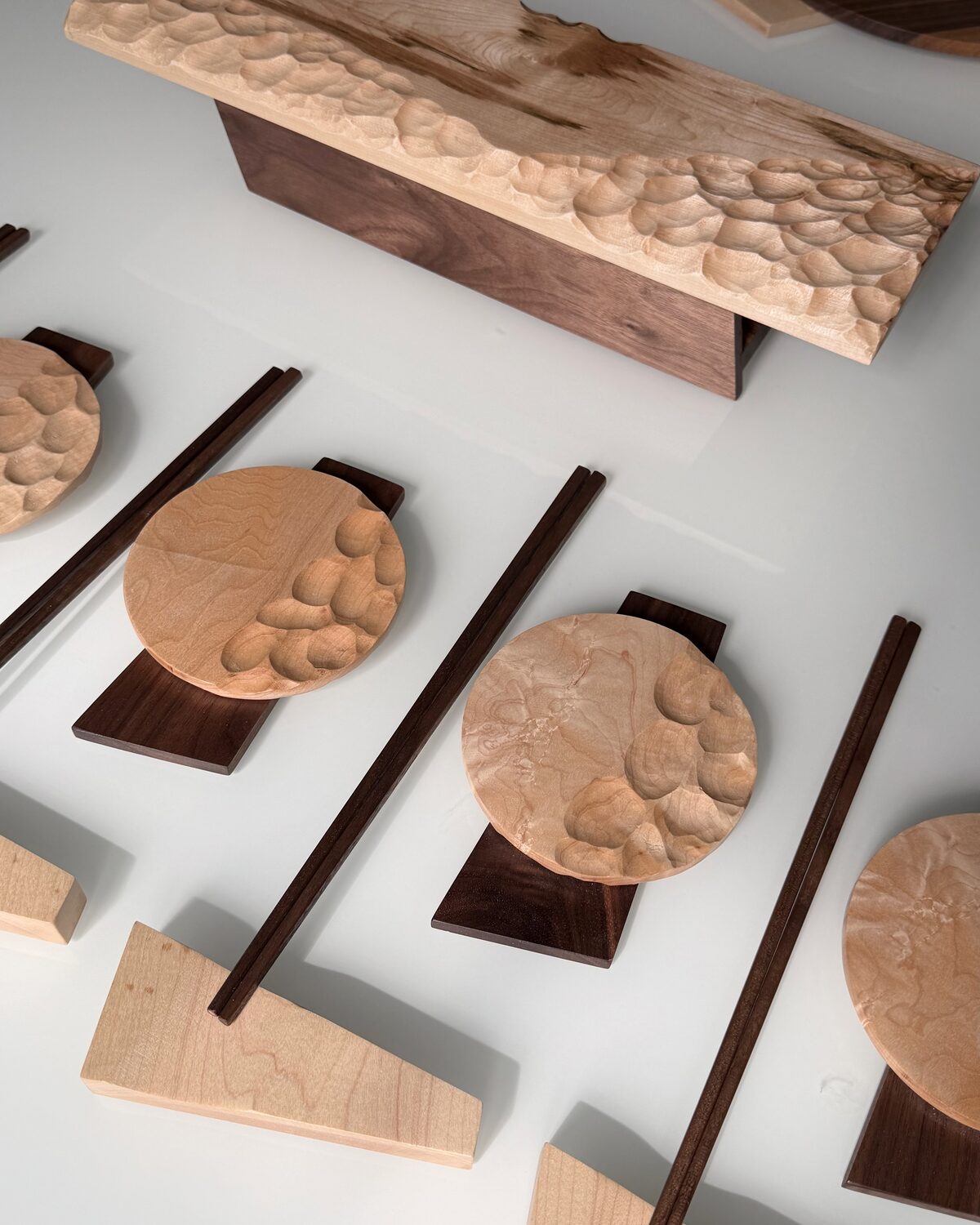 The wave-carved maple board on its walnut base, dishes alongside