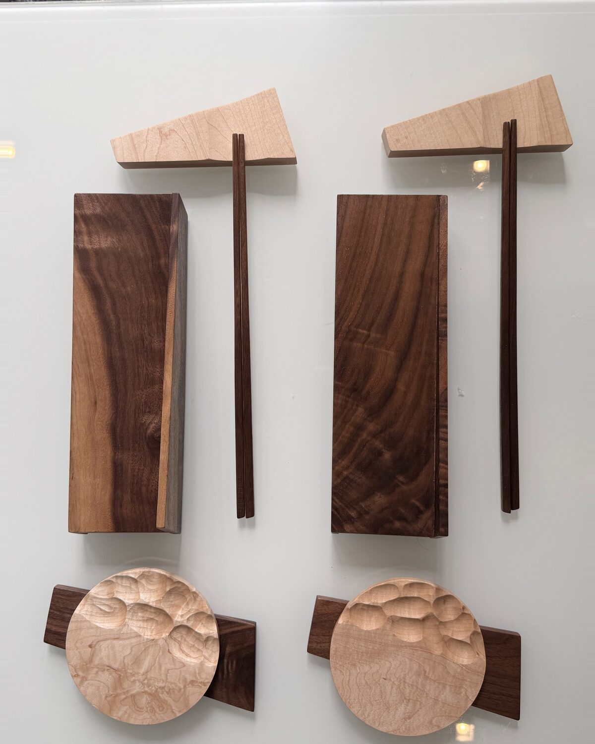 Two settings from above — maple chopstick stands, walnut boards and carved maple dishes